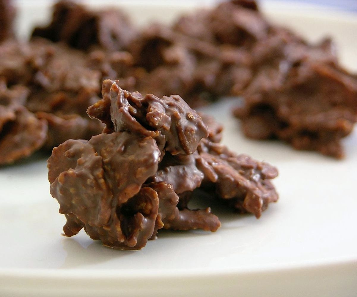 Manos preparando moldes para chocolate con precisión